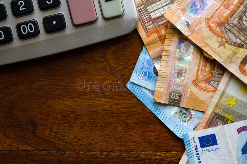 Comment savoir combien je vais toucher au chômage en France 1 calculatrice et billets de banque sur table