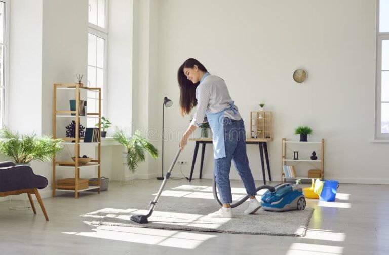 femme de menage souriante avec aspirateur