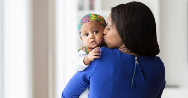 un bebe dans les bras de ses parents