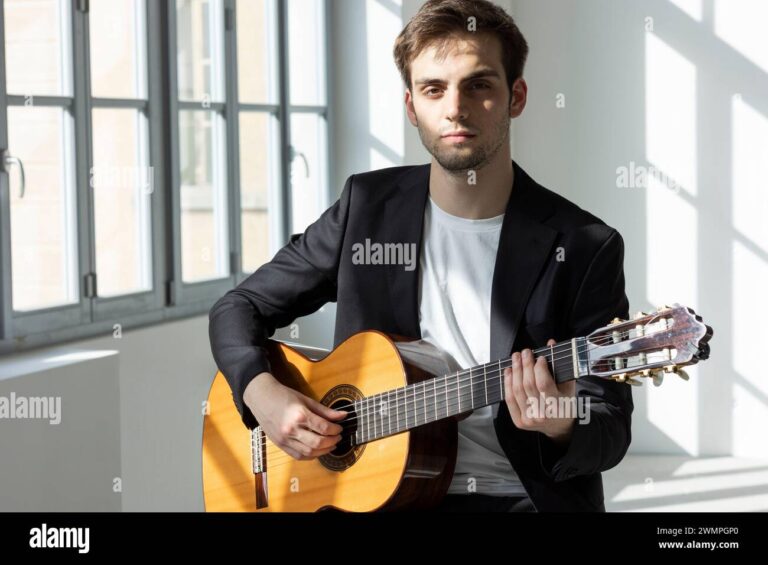 un homme pensif devant une guitare