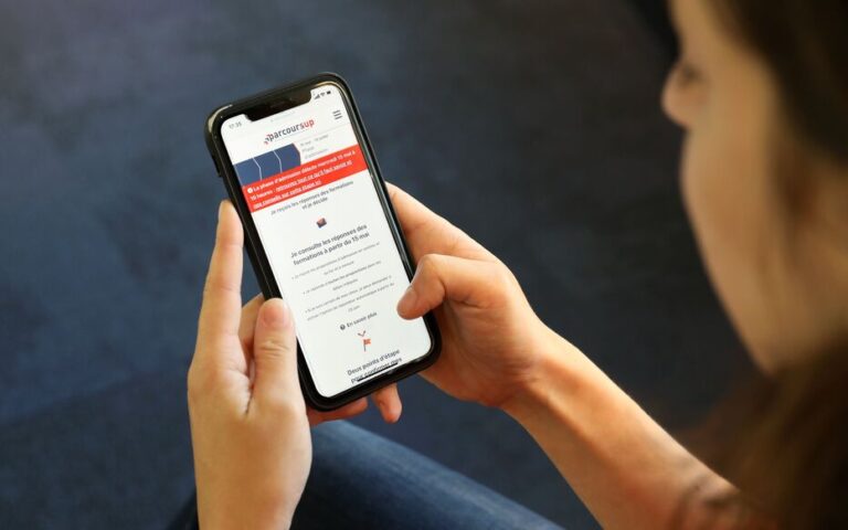 une main tenant un smartphone affichant des resultats